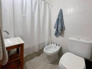 a white bathroom with a toilet and a sink at Cozy Studio in Caballito Your Gateway to Buenos Aires in Buenos Aires