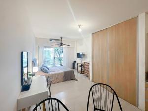 1 dormitorio con 1 cama, escritorio y sillas en Cozy Studio in Caballito Your Gateway to Buenos Aires en Buenos Aires
