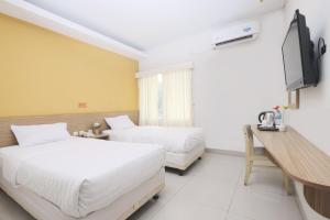 Kama o mga kama sa kuwarto sa Cengkareng Transit Hotel