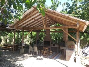 a wooden pergola with chairs and a fireplace at Nueva Tierra, Ayampe in Las Tunas