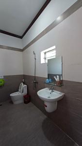 a bathroom with a sink and a toilet and a mirror at Lak View hotel in Lien Son