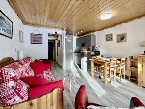 a living room with a red couch and a kitchen at Studio rénové, 4 couchages, proche pistes et commerces - FR-1-330F-231 in La Salle Les Alpes