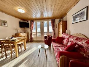 uma sala de estar com um sofá vermelho e uma mesa em Appartement La Salle-les-Alpes, 1 pièce, 4 personnes - FR-1-330F-231 em La Salle Les Alpes