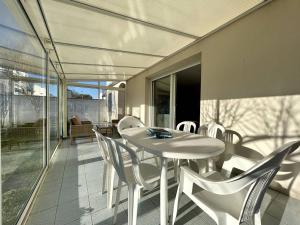 a white table and chairs on a patio at Maison 3 pièces à Dolus d'Oléron, 6 couchages, jardin, wifi, proche piste cyclable et centre - FR-1-246A-281 in Dolus d'Oléron
