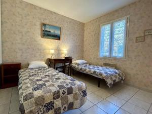 a room with two beds and a table and a window at Maison 3 pièces à Dolus d'Oléron, 6 couchages, jardin, wifi, proche piste cyclable et centre - FR-1-246A-281 in Dolus d'Oléron