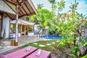 an outdoor dining area of a villa with a swimming pool at Villas SAMALAMA Gili Air in Gili Air