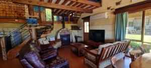 a living room with a couch and a television at Eastern Reef Cottages in Port Campbell