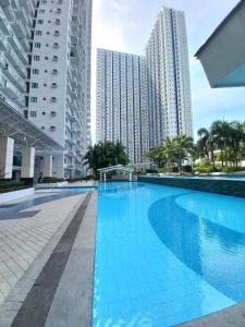 a swimming pool in the middle of some tall buildings at o&o staycation home in Manila