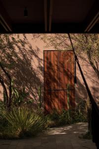 duże drewniane drzwi z płotem na boku budynku w obiekcie Quinta Amores alojamiento w mieście San Miguel de Allende