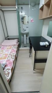 um pequeno quarto com uma cama e um lavatório em Full House em Seul
