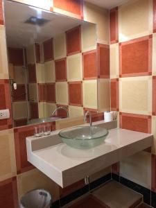 y baño con lavabo y espejo grande. en Relaxation guesthouse en Thalang