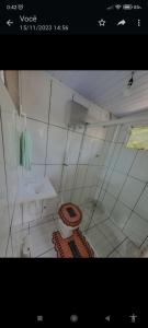 Baño blanco con aseo y lavamanos en Quarto do Madruga en Ilha do Mel