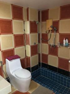 uma casa de banho com um WC e um chuveiro em Relaxation guesthouse em Thalang