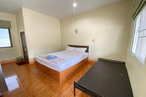 Un dormitorio con una cama y una mesa. en Baan Rim Nam Resort, en Phang Nga
