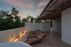 a balcony with a row of pillows on it at Twelve O'Clock - Luxury Villas in Tulum