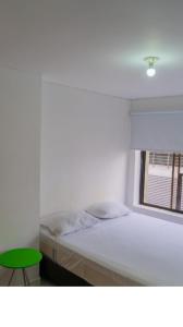 ein weißes Schlafzimmer mit einem Bett und einem Fenster in der Unterkunft 3 Bedroom, 2 bathroom Located Cabecera del LLano. in Bucaramanga