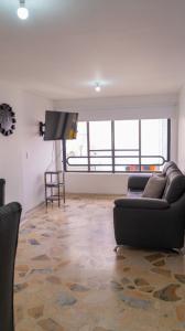 ein Wohnzimmer mit einem Sofa und einem Flachbild-TV in der Unterkunft 3 Bedroom, 2 bathroom Located Cabecera del LLano. in Bucaramanga