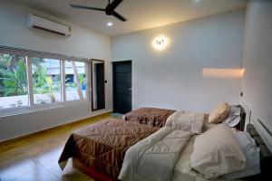 - une chambre avec 2 lits et un ventilateur de plafond dans l'établissement Serene Retreat, à Cochin