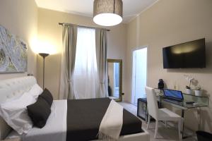 a bedroom with a bed and a desk with a laptop at Town House 57 in Rome