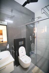 La salle de bains est pourvue de toilettes et d'une douche en verre. dans l'établissement Serene Retreat, à Cochin