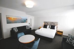 een hotelkamer met een bed en een tafel en stoelen bij Batemans Bay Lodge in Batemans Bay