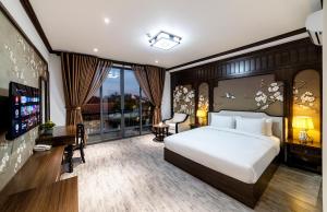 - une chambre avec un grand lit blanc et une fenêtre dans l'établissement Le House DaLat, à Đà Lạt