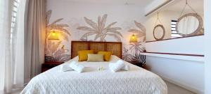 una camera da letto con un grande letto bianco con cuscini gialli di Canari Waterfront Villas a Roches Noires