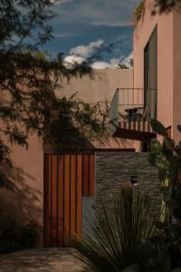 Quinta Amores alojamiento في سان ميغيل دي الليندي: منزل مع بوابة خشبية وشرفة