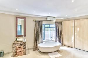 baño con bañera grande y lavamanos en Villa Jesdene, en Ciudad del Cabo