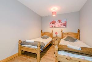 une chambre avec deux lits jumeaux et une table de chevet dans l'établissement Tarporley Holiday Cottage, à Tarporley 26 autres photos