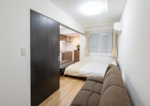 um quarto com uma cama e um sofá num quarto em REPURE OMORI RESIDENCE em Tóquio
