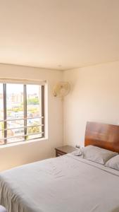 a bedroom with a white bed and a window at Apt Bedroom Apartment era With Doorman in Bucaramanga