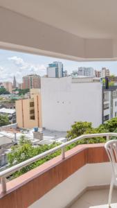 a balcony with a white chair and a view of a city at Apt Bedroom Apartment era With Doorman in Bucaramanga