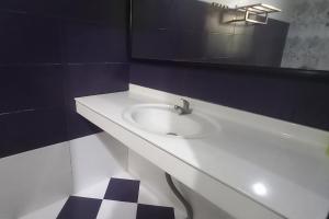 a bathroom with a white sink and a mirror at RedDoorz Syariah near Bypass Krian in Gabung