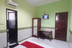 uma casa de banho com espelho e uma televisão na parede em RedDoorz Syariah near Bypass Krian em Gabung