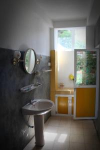 ein Bad mit einem Waschbecken und einem Spiegel in der Unterkunft Singha Holidays in Mirissa