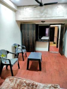 a living room with two chairs and a table at Shivalay Premium Homestay in Ujjain
