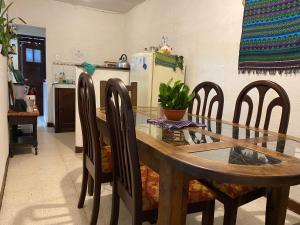 a kitchen with a wooden table and chairs and a refrigerator at Casa De Leon in Antigua Guatemala