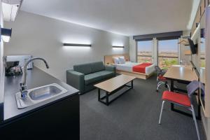 a hospital room with a couch and a bed and a sink at City Express by Marriott Tijuana Insurgentes in Tijuana