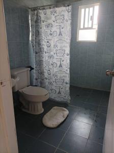 a bathroom with a toilet and a shower curtain at casa de mamá in Santa María Azompa