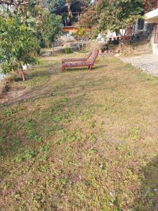 a park bench sitting in the middle of a field at HIMALAYAN AAMA APARTMENT in Pokhara