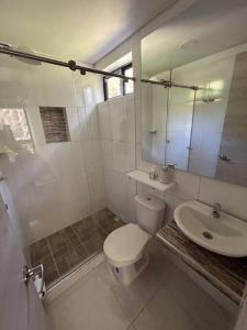 Baño blanco con aseo y lavamanos en Apartamento luxury, en Puerto Triunfo