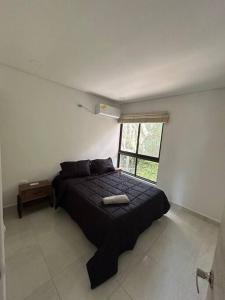 1 dormitorio con cama negra y ventana en Apartamento luxury, en Puerto Triunfo