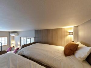 een slaapkamer met een groot wit bed en 2 ramen bij Iwasu-so in Nakatsugawa
