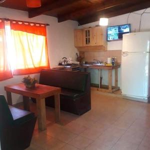 a kitchen with a couch and a table and a refrigerator at Hace tu vida in Tigre +22 photos