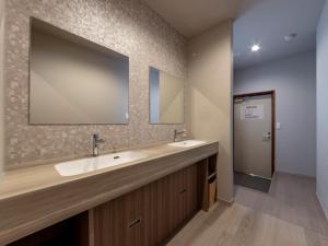 a bathroom with two sinks and a large mirror at Iwasu-so in Nakatsugawa