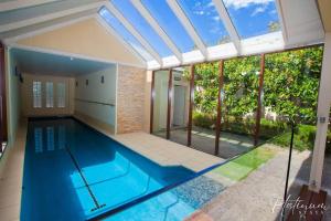 an indoor swimming pool in a house with a ceiling at Sussex House in Ballarat