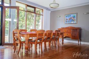 comedor con mesa, sillas y piano en Sussex House en Ballarat