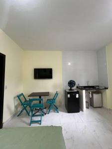 Zimmer mit einem Tisch und Stühlen sowie einem TV in der Unterkunft Kitnet privada confortável em Pontal do Sul in Pontal do Paraná