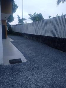 a white fence next to a sidewalk next to a building at Kitnet privada confortável em Pontal do Sul in Pontal do Paraná